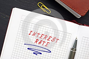 Business concept about INTEREST RATE with sign on the page. AnÃÂ interest rateÃÂ is defined as the proportion of an amount loaned